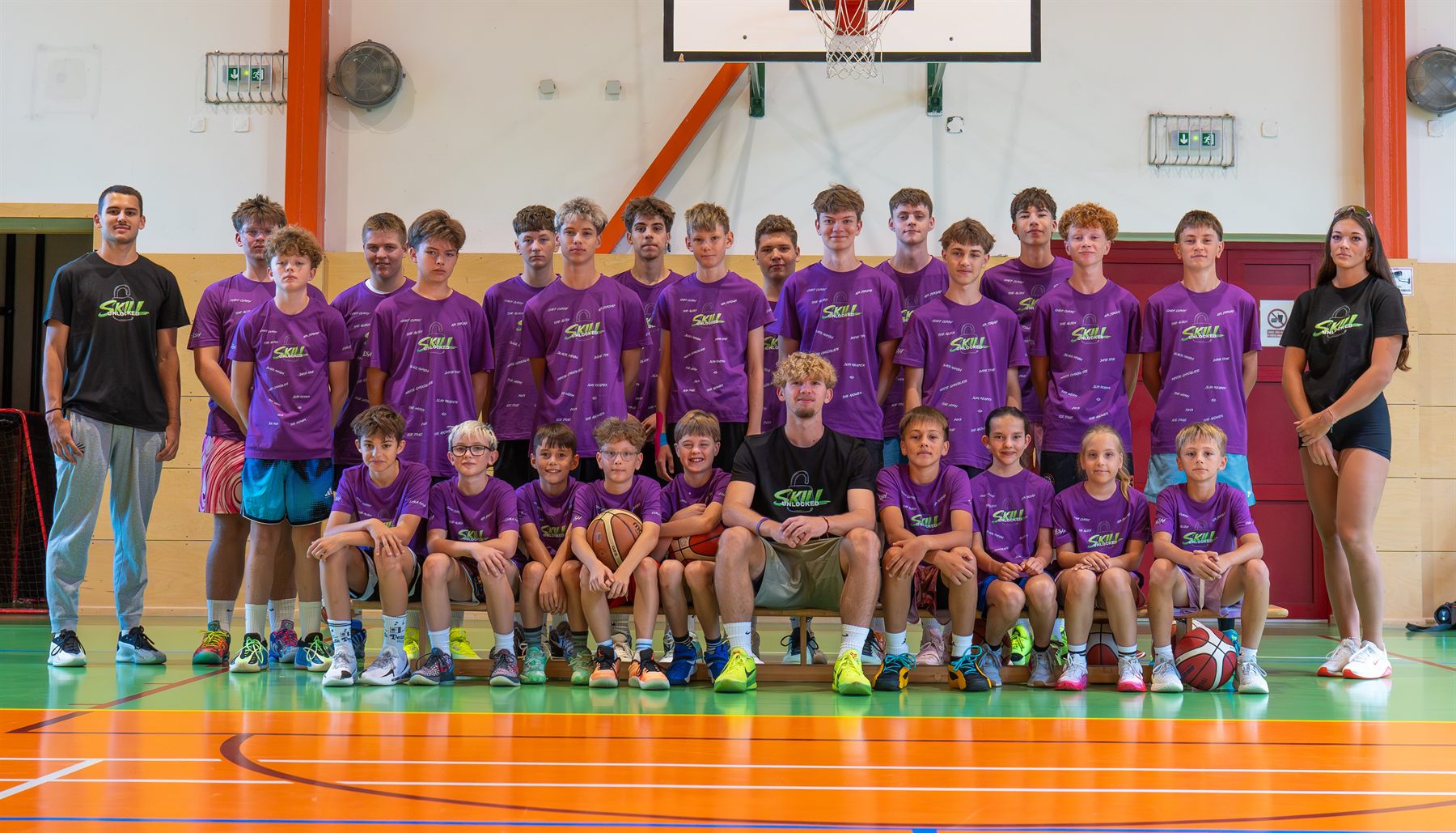 Společná fotka všech účastníků a trenérů kempu Skill Unlocked 2026 v hale